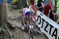 Zwycięzca wyścigu mężczyzn Absalon na stromym, pełnym korzeni zjeździe (Wolfsdrop)