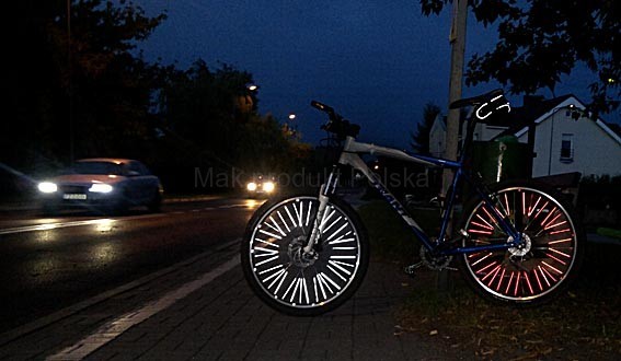 Rower oświetlony reflektorami samochodu.